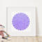Leaning against a wall, beside a stuffed animal, and framed in a white square frame, is the purple, round amulet.